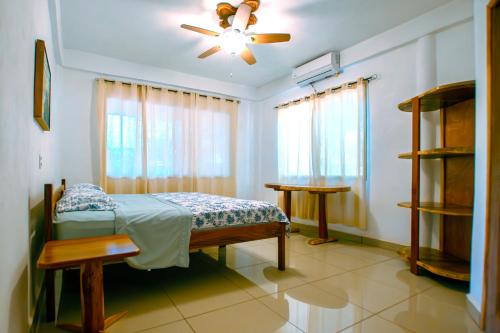 1 dormitorio con 1 cama y ventilador de techo en 1 Large beautiful poolside condo with AC! Great Location!, en Carrillo