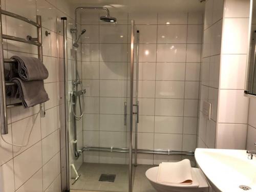 ein Bad mit einer Dusche, einem WC und einem Waschbecken in der Unterkunft Great 1 bedroom apartment in Lidingö in Kottla