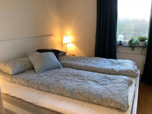 ein Schlafzimmer mit einem Bett mit einer Lampe und einem Fenster in der Unterkunft Great 1 bedroom apartment in Lidingö in Kottla