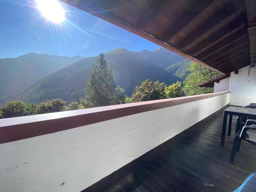a balcony with a table and a view of mountains at Casa Polly a Saint Rhemy En Bosses in Saint-Rhémy-en-bosses