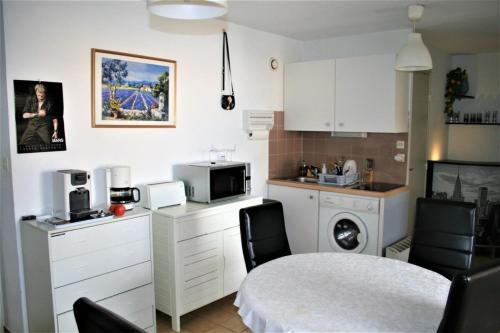 une cuisine avec une table et des chaises et un micro-ondes dans l'établissement Between sea and marina, à Frontignan