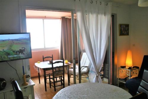 un salon avec une table et une salle à manger dans l'établissement Between sea and marina, à Frontignan