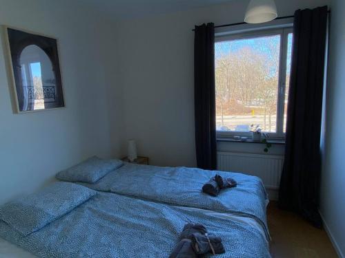 a bedroom with two beds in front of a window at Spacious 1 bedroom flat, Lidingo in Kottla