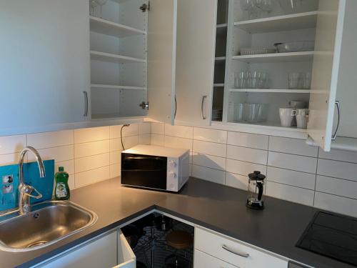 cocina con fregadero y microondas en Cozy 1 bedroom flat on Lindingo, en Kottla