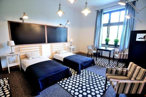 ソポトにあるVictus Apartamenty, Apartament Flamingoのベッド2台と大画面テレビが備わる客室です。