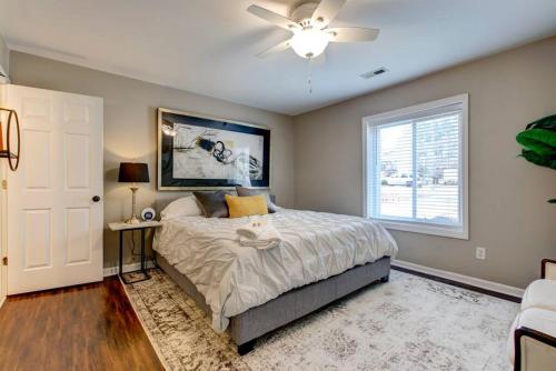 a bedroom with a bed with a ceiling fan and a window at Renovated Raleigh Bungalow in Raleigh