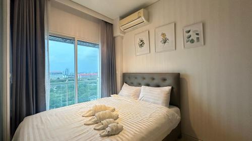 a bed with a teddy bear on it with a window at Veranda Residence pattaya By Sea in Jomtien Beach