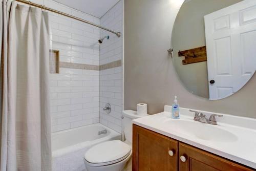 a bathroom with a toilet and a sink and a mirror at Renovated Raleigh Bungalow in Raleigh