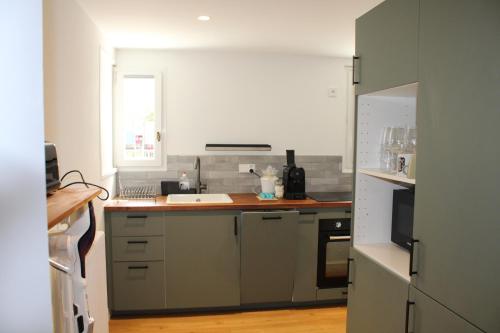 une cuisine avec un évier et un plan de travail dans l'établissement Maison à 7 min à pied de la Côte des Basques (océan), à Biarritz