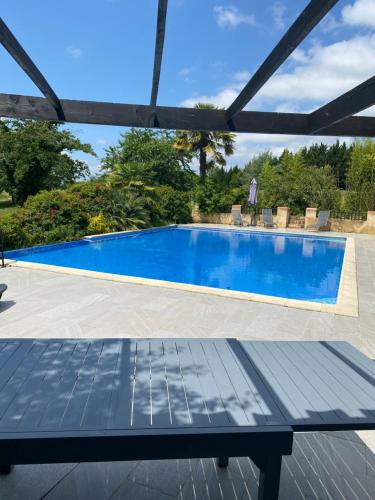 - une piscine avec une table en face dans l'établissement A Gaillut, à Caupenne-dʼArmagnac