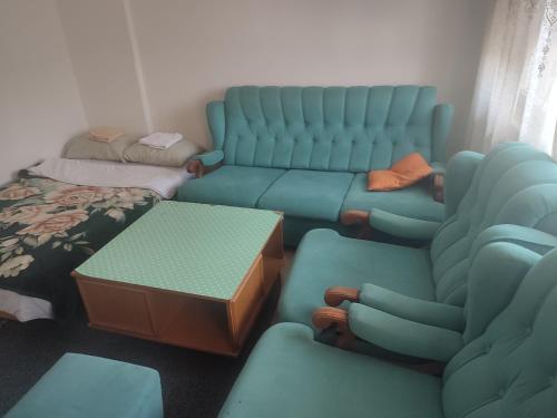 a living room with blue chairs and a couch at Apartman Retro Una in Banja Luka
