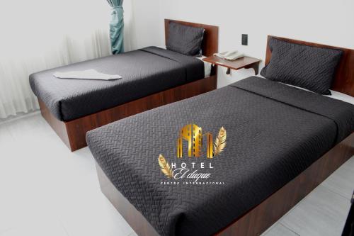 two beds in a room with a hotel logo at Hotel el Duque Internacional, Bogotá in Bogotá