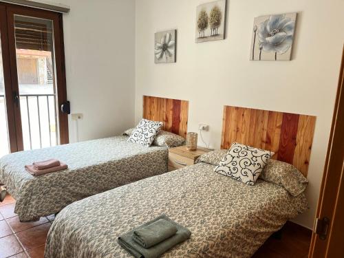 1 Schlafzimmer mit 2 Betten und einem Fenster in der Unterkunft Alojamiento Rural El Morenal in Tragacete