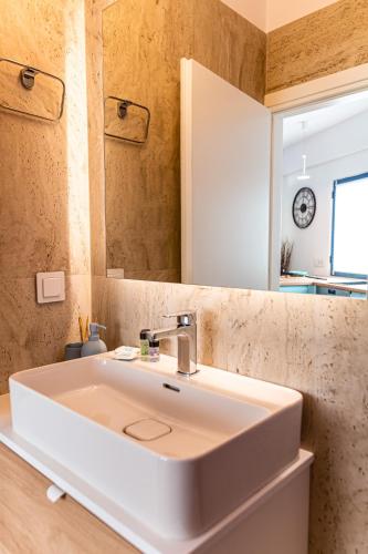 a bathroom with a white sink and a mirror at Azul Studio Preveza in Preveza