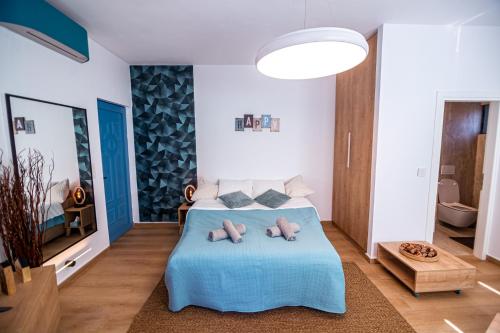 a bedroom with a blue bed with two teddy bears on it at Azul Studio Preveza in Preveza