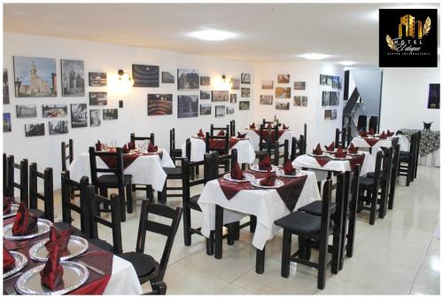 uma sala de jantar com mesas e cadeiras e quadros na parede em Hotel el Duque Internacional em Bogotá