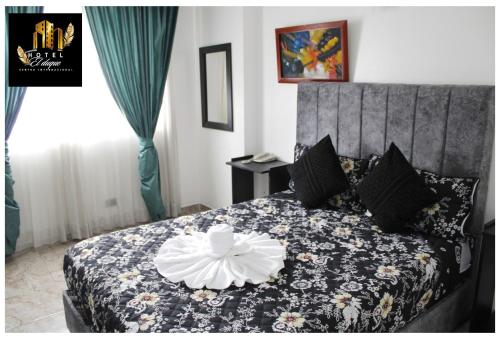 Un dormitorio con una cama con una flor blanca. en Hotel el Duque Internacional, en Bogotá