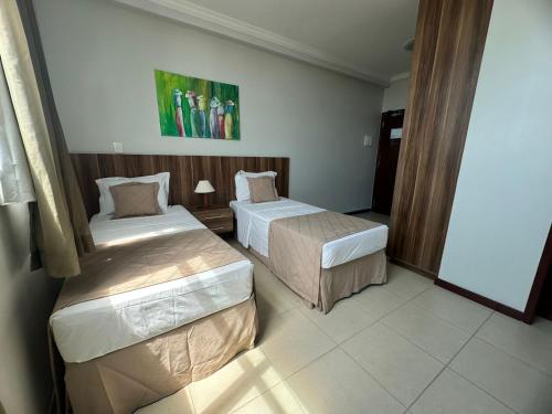 a room with two beds in a hotel room at Hotel Atlantico Macaé By Inn House in Macaé