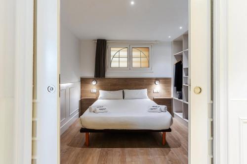 een slaapkamer met een wit bed en een raam bij Enjoybcn Plaza Catalunya Apt. in Barcelona