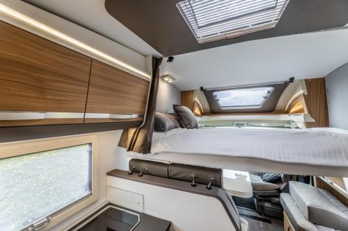 1 dormitorio en una cabaña con cama y ventana en Campiri Base Prague - motorhomes & RVs rental company en Tuchoměřice