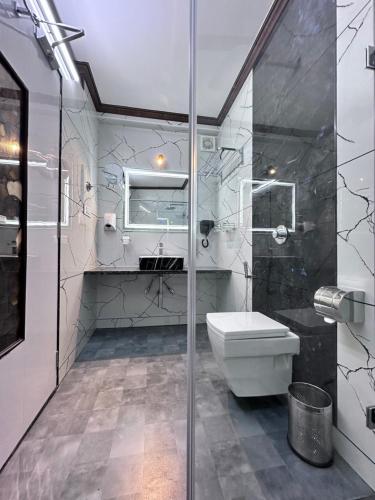 a bathroom with a toilet and a glass shower at Beverly villa in Ooty
