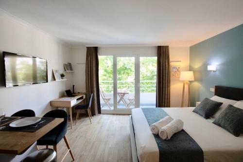Habitación de hotel con cama, escritorio y mesa. en Studio pour séjours d’affaires à La Défense, en Courbevoie