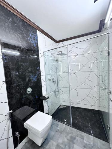 a bathroom with a toilet and a glass shower at Beverly villa in Ooty
