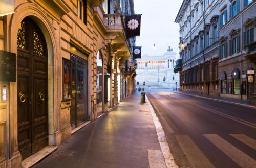 an empty street in a city with buildings at Via Del Corso Home Roma in Rome