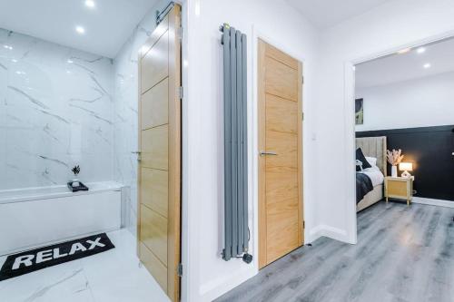a bathroom with a shower and a door to a bedroom at Luxury Didsbury 2 Bed Apartment in Manchester