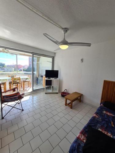 - un salon avec un lit et un ventilateur de plafond dans l'établissement Between beach and marina, à Frontignan