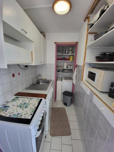une petite cuisine avec un évier et une cuisinière dans l'établissement Between beach and marina, à Frontignan