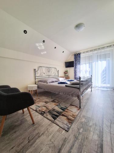 a bedroom with a bed and a living room at Noclegi Fregata - Pokoje Gościnne w Solinie 661-459-339 in Solina