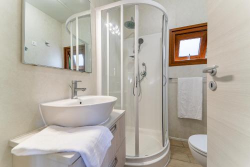 ein weißes Badezimmer mit Waschbecken und Dusche in der Unterkunft Arcobaleno Village H in Marina di Bibbona