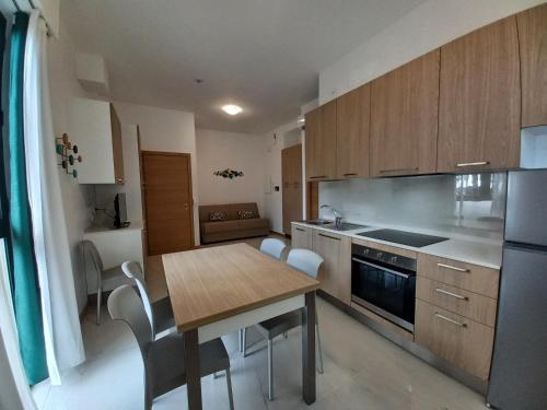 a kitchen with a wooden table and a dining room at Residence Stella Marina in Cupra Marittima