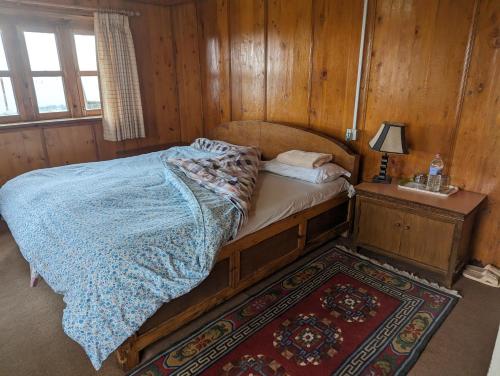 ein Schlafzimmer mit einem Bett in einem Holzzimmer in der Unterkunft Lukla Himalaya Lodge in Lukla