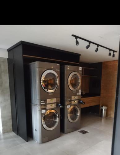 a laundry room with three washing machines in it at Century Park 607 - Apartamento na melhor região da Cidade Baixa in Porto Alegre