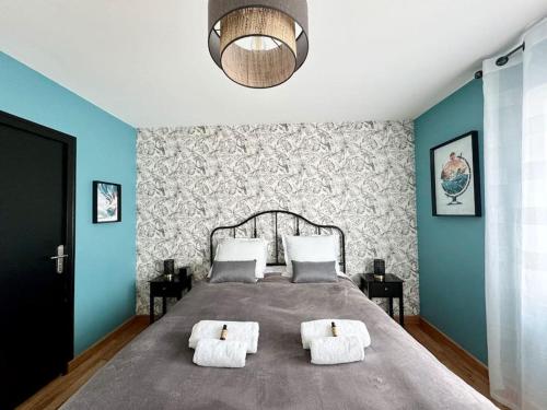 um quarto com uma cama grande e 2 almofadas em L'Archipel, belle maison au coeur de Fouesnant em Fouesnant