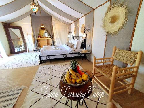 a room with a bed and a bowl of fruit at Luna luxury camp in Merzouga