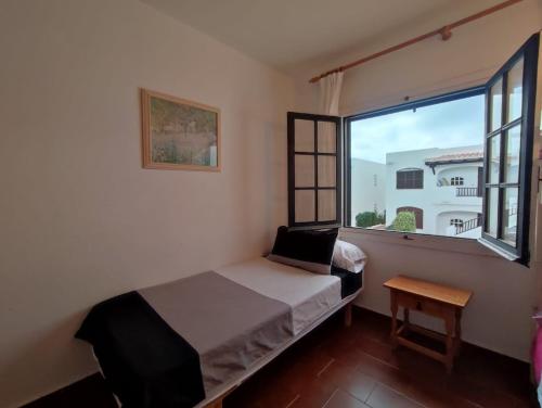 a bedroom with a bed and a large window at Apartamento Menorca son parc in Son Parc