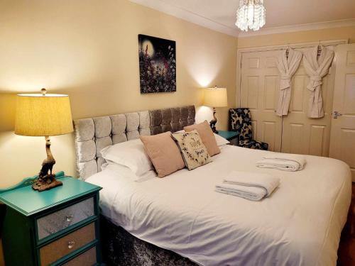 a bedroom with a white bed with a lamp on a table at Apartment 2 in Darlington