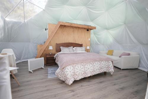 聖地亞哥的住宿－Refugio Atreyu，帐篷内一间卧室,配有一张床和一张沙发