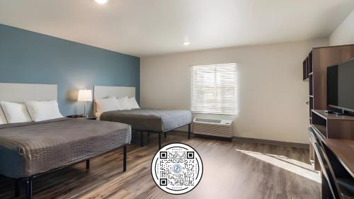 WoodSpring Suites Libertyville - Chicago في ليبرتفيل: غرفه فندقيه سريرين وتلفزيون