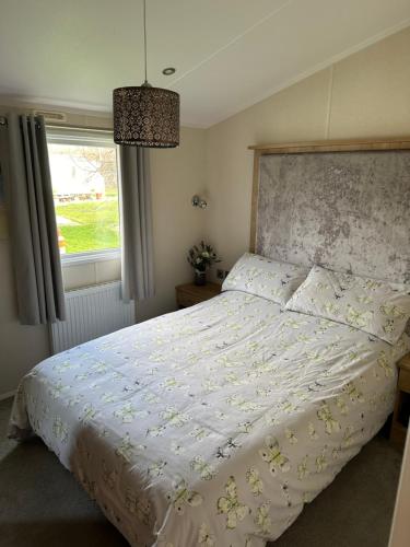 - une chambre avec un lit doté d'une couette blanche et d'une fenêtre dans l'établissement Chorley close, à Walton-on-the-Naze