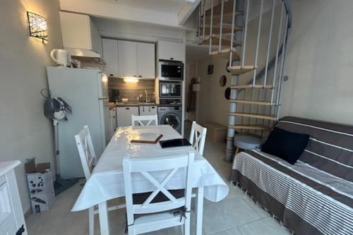 eine Küche und ein Esszimmer mit einem Tisch und einem Kühlschrank in der Unterkunft Maisonette by the sea in Frontignan