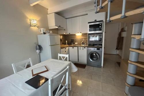 eine Küche mit einem Kühlschrank und einem Tisch im Zimmer in der Unterkunft Maisonette by the sea in Frontignan
