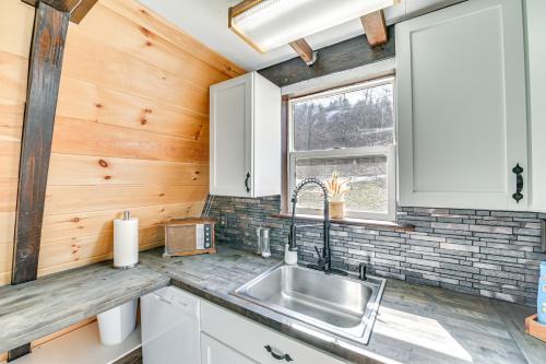 eine Küche mit einem Waschbecken und einem Fenster in der Unterkunft A-Frame Catskills Cabin with Scenic Views and Hot Tub! in Stamford