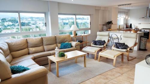ein Wohnzimmer mit einem Sofa und einem Tisch in der Unterkunft Appartement Jumate te Altea-Albir in Altea