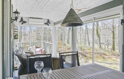 a dining room with a table and a large window at 2 Bedroom Awesome Home In Örkeljunga in Orkelljunga