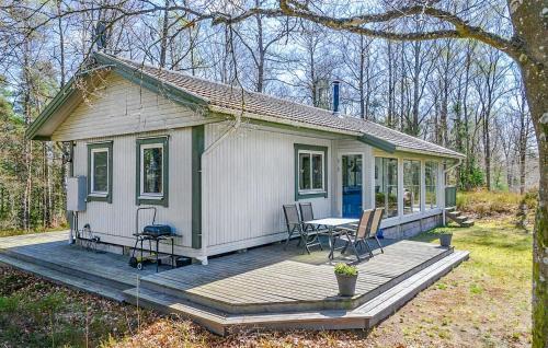 a small house with a table and chairs on a deck at 2 Bedroom Awesome Home In Örkeljunga in Orkelljunga