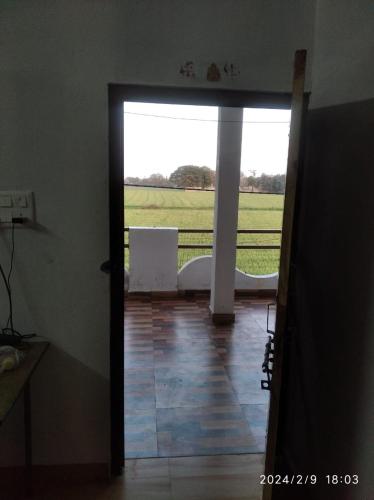 an open door to a room with a view of a field at Gehelot DharmShala in Ujjain